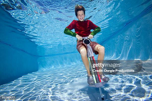 boy jumping on pogo stick underwater - pogo stock-fotos und bilder