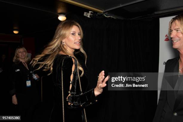 Model Susan Holmes McKagan waves next to bassist Duff McKagan leaving the carpet during the MusiCares Concert for Recovery benefit at The Showbox on...