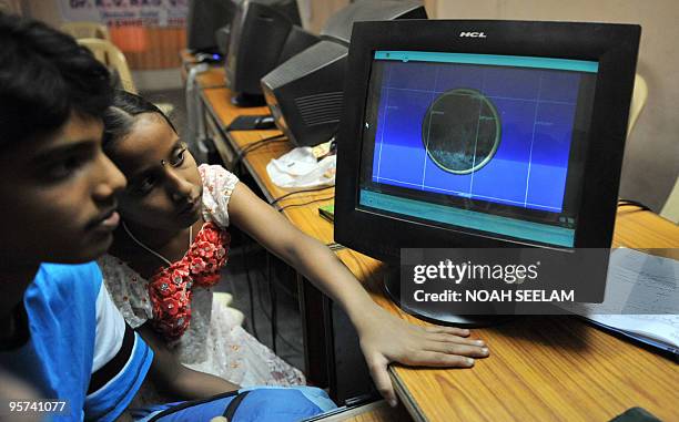 Indian school students Tarun and Harshini present a computer generated solar eclipse model at Kennedy High School in Hyderabad on January 13, 2010....