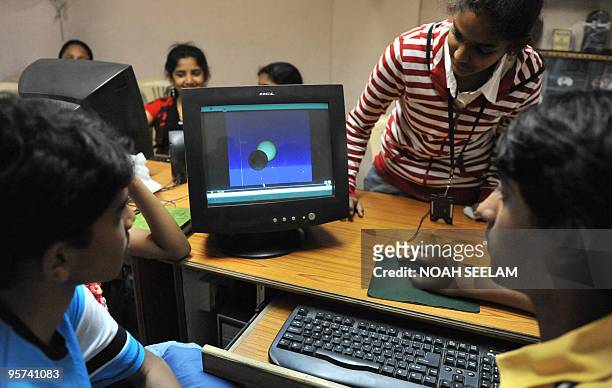 Indian school students M.S.Tarun and Sindhu present a computer generated solar eclipse model at Kennedy High School in Hyderabad on January 13, 2010....