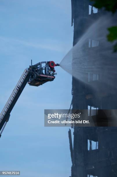 London,UK. 14th June 2017.View of fire brigade pouring water on to smouldering remnants of Grenfell Tower in West London,UK.© Julio Etchart/Alamy...