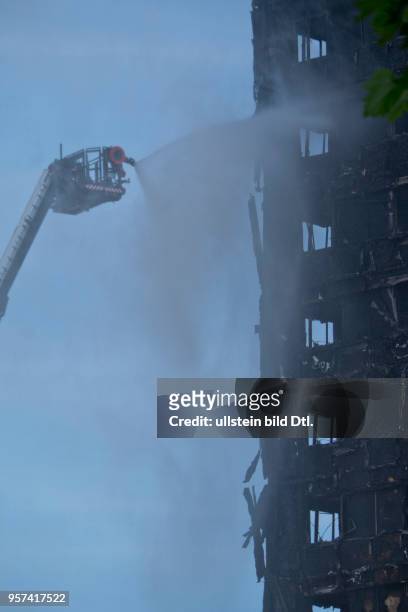 London,UK. 14th June 2017.View of fire brigade pouring water on to smouldering remnants of Grenfell Tower in West London,UK.© Julio Etchart/Alamy...