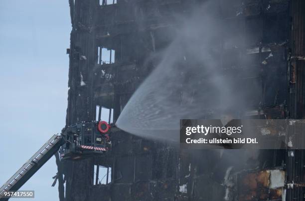 London,UK. 14th June 2017.View of fire brigade pouring water on to smouldering remnants of Grenfell Tower in West London,UK.© Julio Etchart/Alamy...