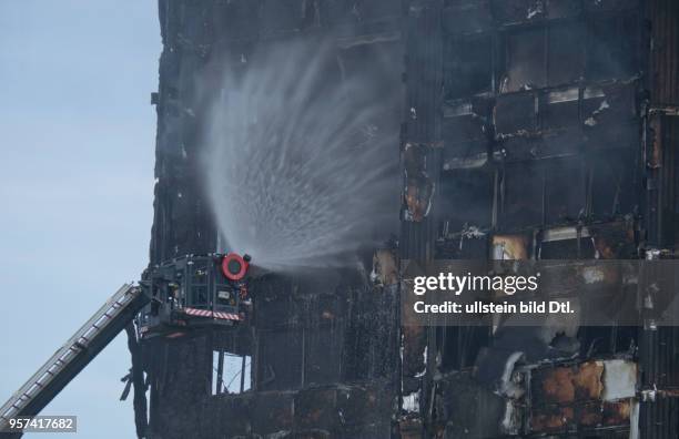 London,UK. 14th June 2017.View of fire brigade pouring water on to smouldering remnants of Grenfell Tower in West London,UK.© Julio Etchart/Alamy...