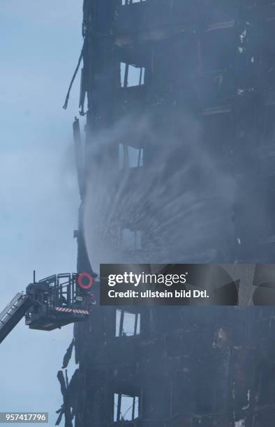 London,UK. 14th June 2017.View of fire brigade pouring water on to smouldering remnants of Grenfell Tower in West London,UK.© Julio Etchart/Alamy...