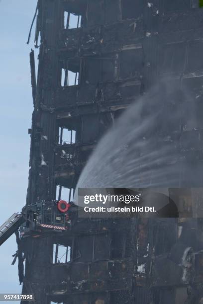 London,UK. 14th June 2017.View of fire brigade pouring water on to smouldering remnants of Grenfell Tower in West London,UK.© Julio Etchart/Alamy...