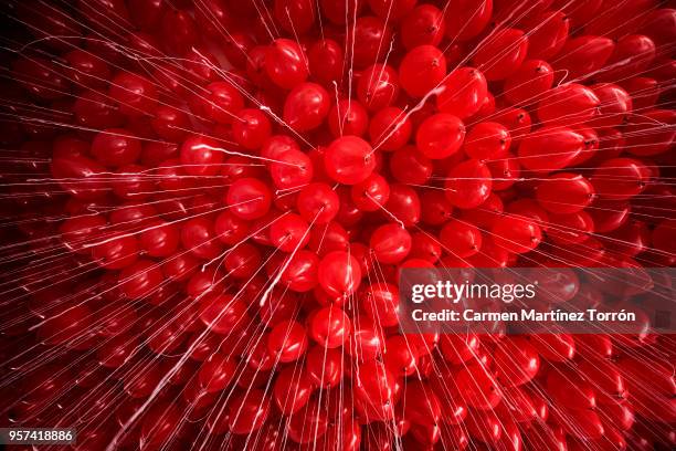 full frame shot of red helium balloons against ceiling in a coruña, spain. - balloon party stock-fotos und bilder