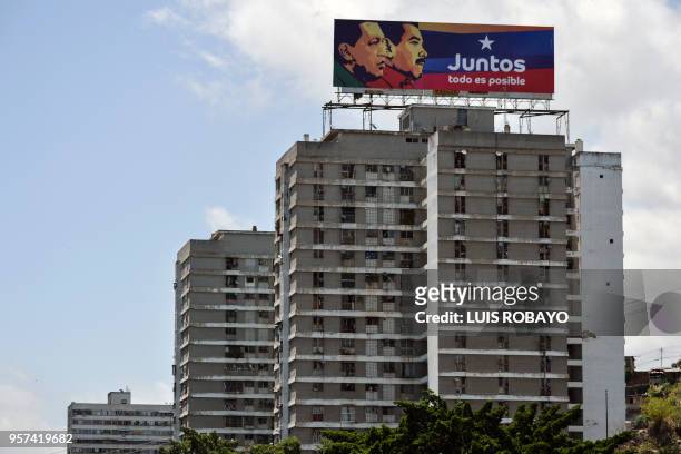An electoral billboard of Venezuelan President and reelection candidate Nicolas Maduro is seen atop a building, in Caracas on May 11, 2018....