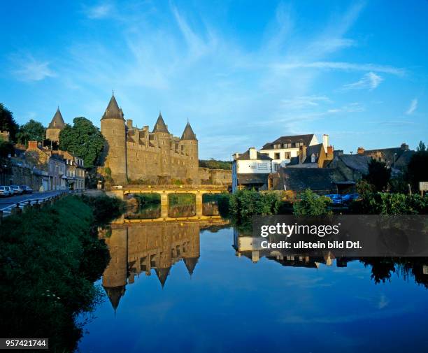 Die wehrhaft-trutzigen Tuerme und Mauern des Chateau de Rohan, Schloss der bretonischen Familie Rohan in Josselin, spiegeln sich im Wasser des...