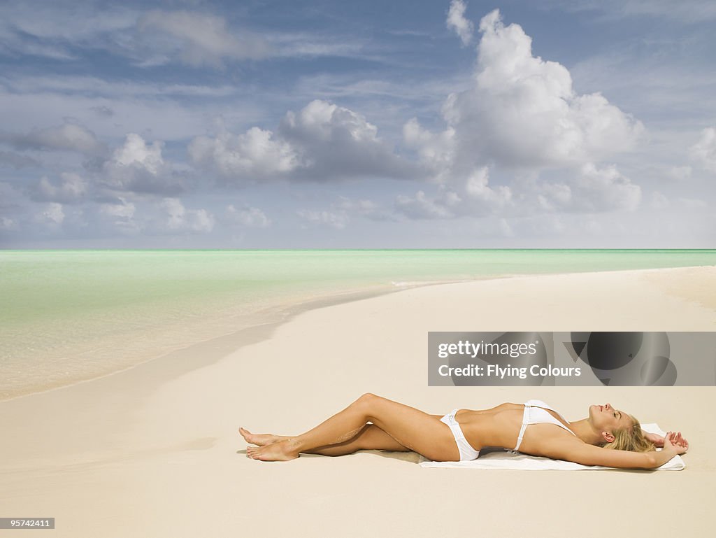 Woman sunbathing on deserted beach