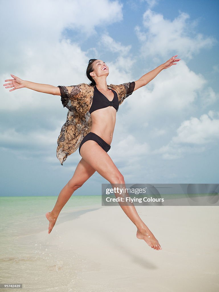 Woman jumping in the air on beach