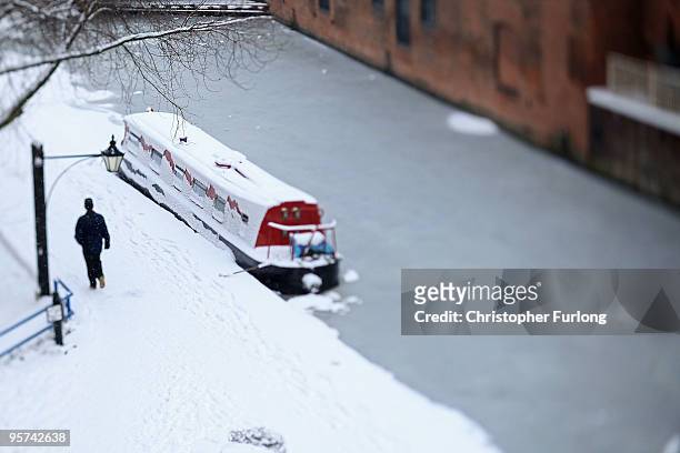 Member of the public makes their way across a snow covered Brindley Palce Canal Basin on January 13, 2010 in Birmingham, England. Fresh snowfall has...