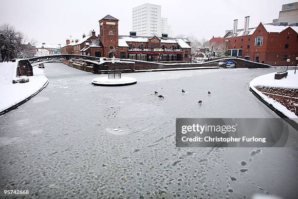 Member of the public makes their way across a snow covered Brindley Palce Canal Basin on January 13, 2010 in Birmingham, England. Fresh snowfall has...