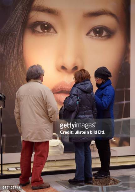 Passers-by are standing in front of a shop in the shopping mall Galleria Vittorio Emanuele II in Milan ,