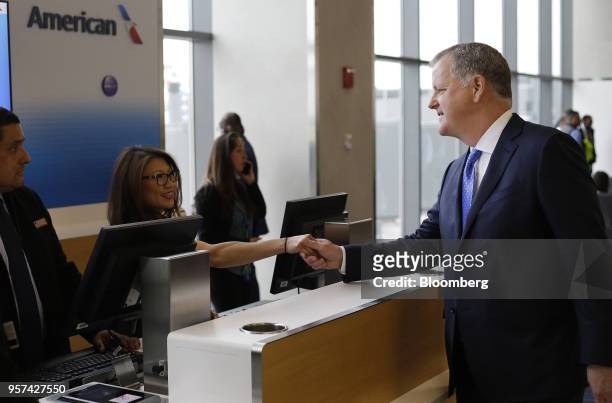 Doug Parker, chairman and chief executive officer of American Airlines Group Inc., shakes hands with an employee during an event to mark the opening...