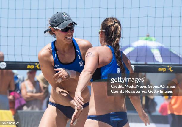 Lauren Fendrick and Brooke Sweat, from left, celebrate a point against a team from Colombia during the Huntington Beach Open on Thursday, May 3, 2018.