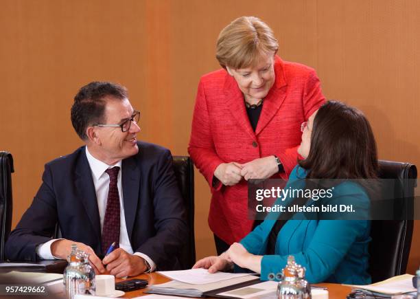 Ministers Gerd MUELLER , CSU , and Andrea NAHLES , SPD , are talking to Chancellor Angela MERKEL , CDU , during a cabinet meeting