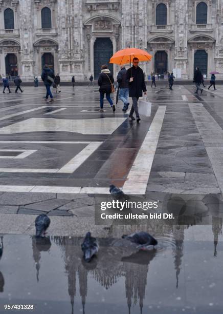 The cathedral Santa Mariae Nascenti in Milan is reflecting in a puddle on cathedral square ,