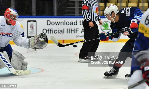 Neal Pionk of the United States hits a puck watched by South Korea's Matt Dalton during the group B match USA versus South Korea of the 2018 IIHF Ice...