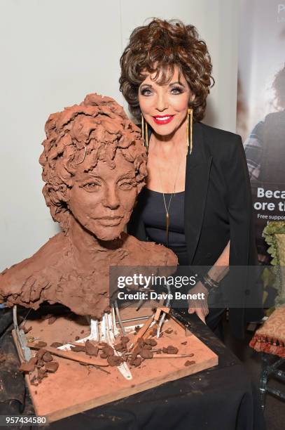 Dame Joan Collins poses at a live sculpting in support of Penny Brohn UK Charity at the London Film Museum on May 11, 2018 in London, England.