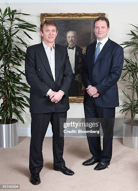 Paul Ross, chief executive officer of Iveagh Ltd., left, stands with Rory Guinness, director of strategic investment of Iveagh Ltd., by a portrait of...