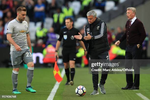 Jose Mourinho manager of Manchester United gestures at Luke Shaw as David Moyes Manager of West Ham United looks on during the Premier League match...