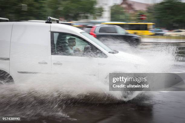 Deutschland Germany Berlin Szenen aus der Regenburger Str. WÃ¤hrend heftiger RegenfÃ¤lle. Autos fahren durch Wasserlachen.