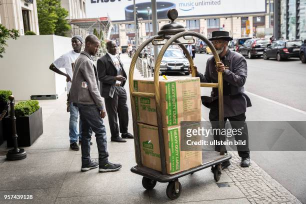 Deutschland Germany Berlin UnterstÃ¼tzer des senegalesischen PrÃ¤sidenten vor dem Ritz Carlton Hotel am Potsdamer Platz. Ein Doorman schiebt einen...