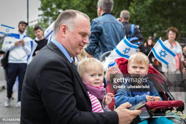 Germany Deutschland Berlin Pro-Israel-Demonstration auf dem Kurfürstendamm Richtung Breitscheidtplatz. Vater mit Kindern , mit Milchflasche und Handy.