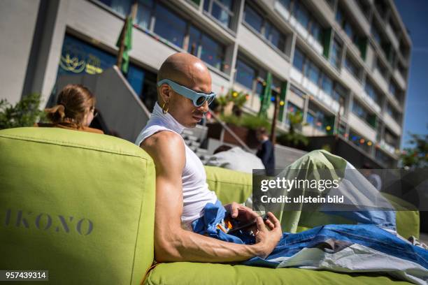 Deutschland Germany Berlin Ein Mann mit blauer Sonnenbrille entspannt sich auf der Terasse des Bikinihauses.
