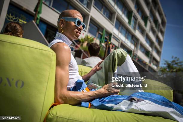 Deutschland Germany Berlin Ein Mann mit blauer Sonnenbrille entspannt sich auf der Terasse des Bikinihauses.