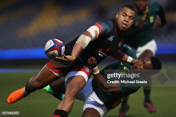 Ollie Lawrence of England feeds a pass as Wandisile Simelane of South Africa tackles during the International match between England U20's and South...