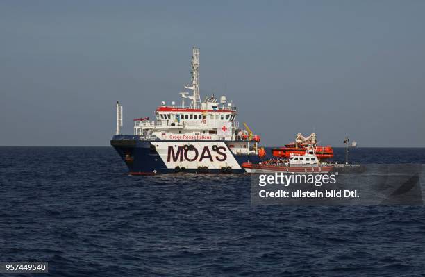 Zivile Seenotrettung im Mittelmeer vor Libyen. Hier: Die italienische Küstenwache bringt Geflüchtete von Bord der NGO 'LIFEBOAT' zum Versorger 'Topaz...