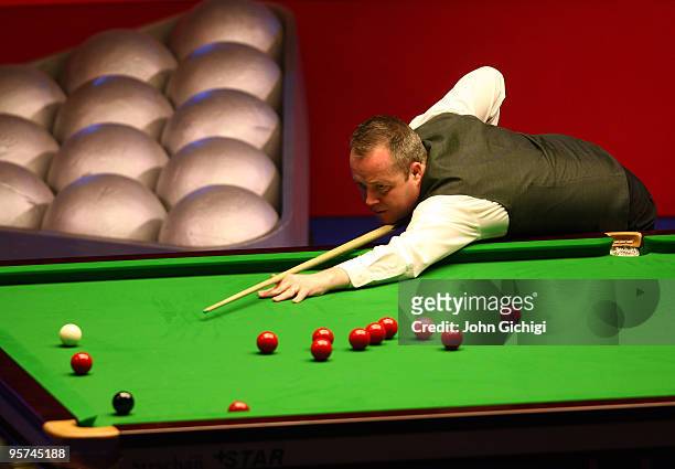 John Higgins of Scotland takes a shot in his match against Mark Allen of Ireland during the PokerStars Masters snooker tournament at Wembley Arena on...