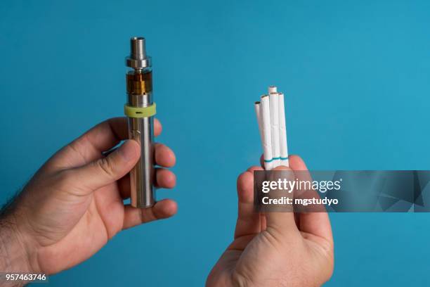 men holding electronic cigarette on colored background background - e cigarettes stock pictures, royalty-free photos & images