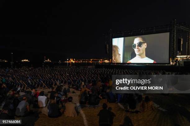 People watch late on May 11, 2018 the 30th anniversary screening of the film "Le Grand Bleu" at the Cinema de la Plage on the sidelines of the 71st...