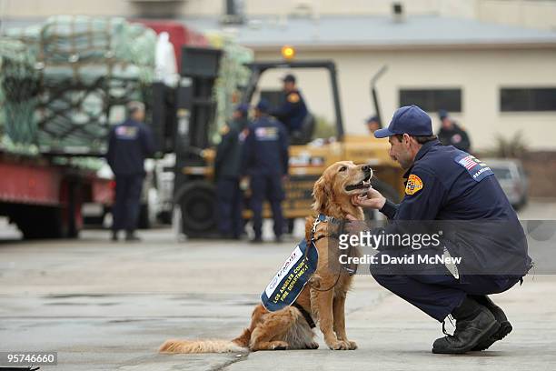 Los Angeles County Fire Department urban search and rescue dog Baxter and handler Gary Durian prepare for deployment as other team members load US...
