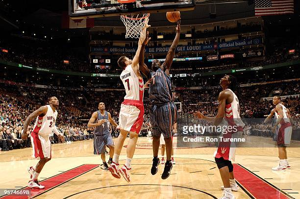 DeSagana Diop of the Charlotte Bobcats lays up a shot against Andrea Bargnani of the Toronto Raptors during the game on December 30, 2009 at Air...