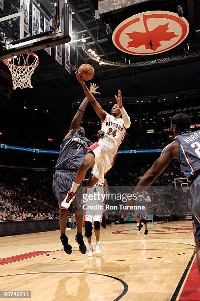 Sonny Weems of the Toronto Raptors lays up a shot against DeSagana Diop of the Charlotte Bobcats during the game on December 30, 2009 at Air Canada...
