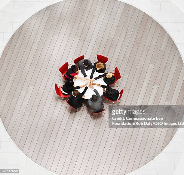 overhead view of people joining hands - moving down to seated position stock pictures, royalty-free photos & images