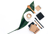Flat lay Modern blogger concept. Workspace with eco Kraft items coffee and green leaf on white background. Home office desk.