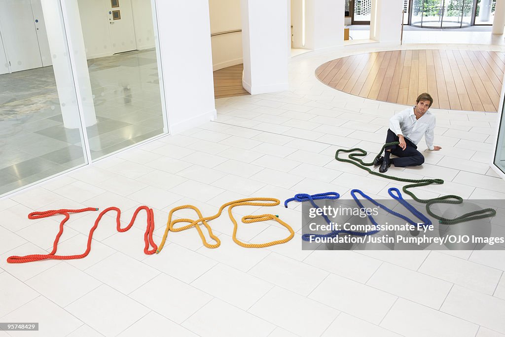 Man sitting beside the word imagine