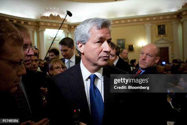 Jamie Dimon, chairman, president and chief executive officer of JPMorgan Chase & Co, center, makes his way through a crowd of media at the U.S....