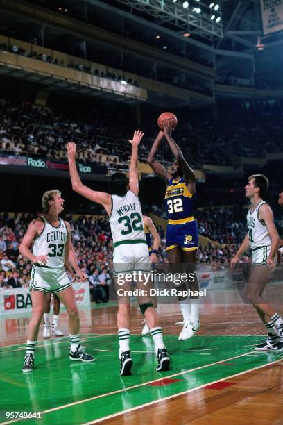 Herb Williams of the Indiana Pacers shoots a jump shot against Kevin McHale and Larry Bird of the Boston Celtics during a game played in 1987 at the...