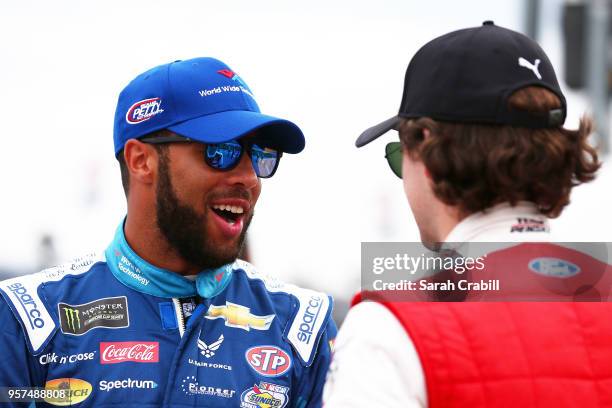 Darrell Wallace Jr., driver of the World Wide Technology Chevrolet, and Ryan Blaney, driver of the REV Group Ford, talk on the grid during qualifying...