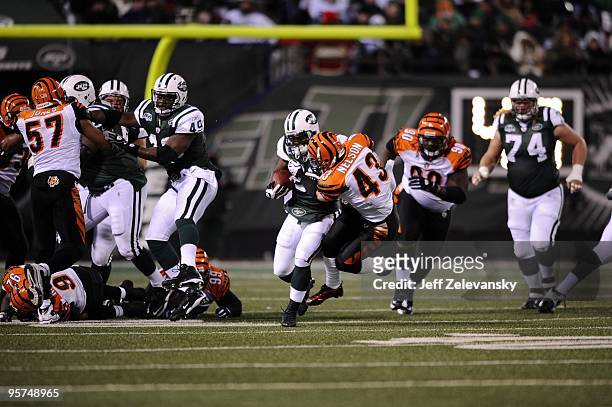 Running back Shonn Greene of the New York Jets tries to run the ball past against Tom Nelson of the Cincinnati Bengals at Giants Stadium on January...
