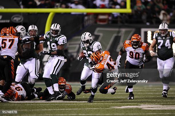 Running back Shonn Greene of the New York Jets tries to run the ball past against Tom Nelson of the Cincinnati Bengals at Giants Stadium on January...