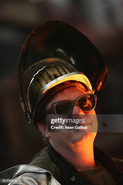 Worker's face is lit by light from molten iron flowing from a blast furnace at the ThyssenKrupp steelworks on January 13, 2010 in Duisburg, Germany....