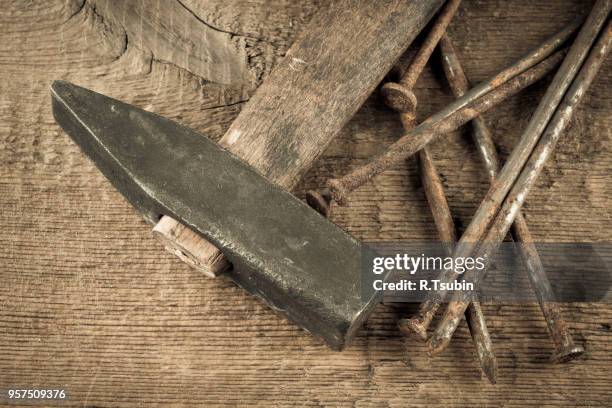 vintage old hammer with rusty nails on wood table background - bricolage stock-fotos und bilder