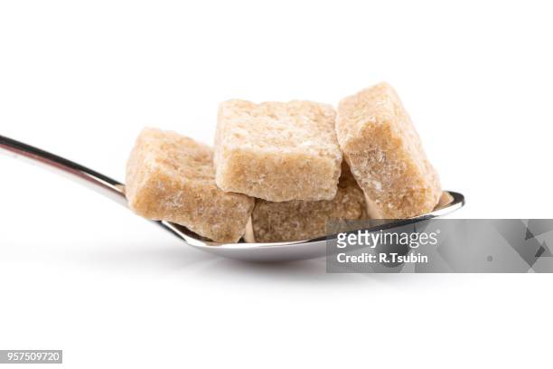 cubes of brown sugar on a metal spoon - panela stock pictures, royalty-free photos & images